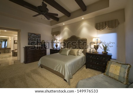 Silk Cover On Double Bed In Spacious Bedroom With Beamed Ceiling At Home