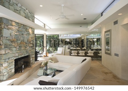 Sunken seating area and stone fireplace with dining area in background at home