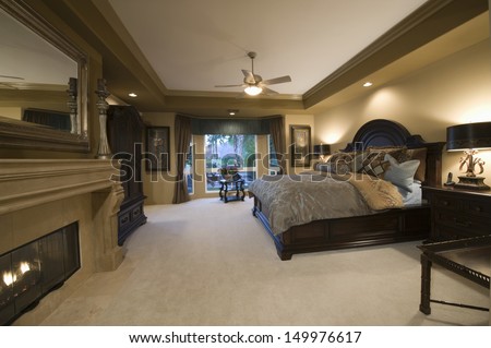 View Of A Spacious Bedroom With Dark Wood Furniture At Home