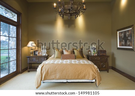 Chandelier Hanging Over Tidy Bed At Home