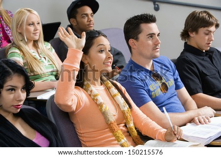 Female student raising hand during class lecture Female student raising hand during class lecture