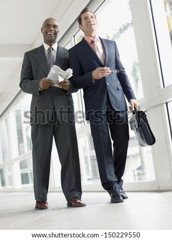 Full length of multi ethnic businessmen walking in office corridor
