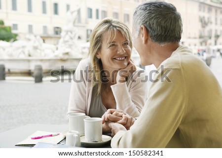 Happy couple looking at each other at outdoor cafe in Rome Happy couple looking at each other at outdoor cafe in Rome