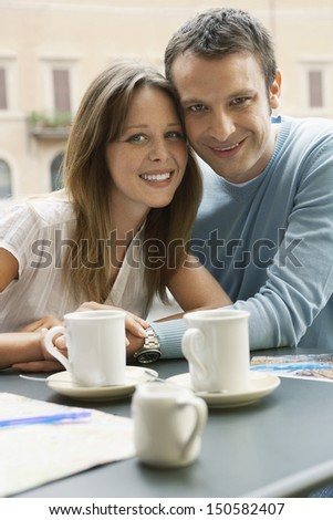 Portrait of happy young couple at outdoor cafe in Rome