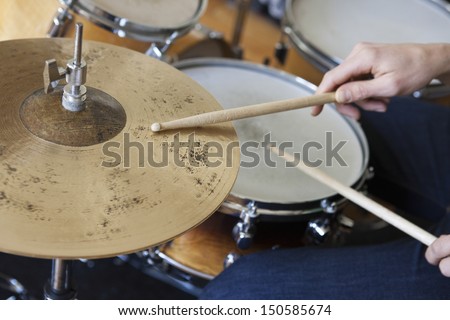 Closeup of hands playing drum set