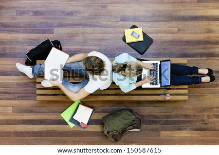 Top view of male and female university students studying