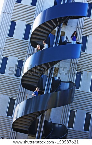 Students on modern spiral staircase at university campus