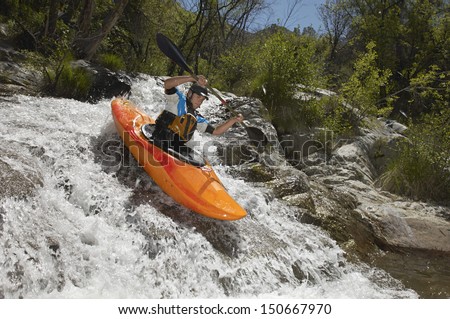 Man Kayaking On Mountain River