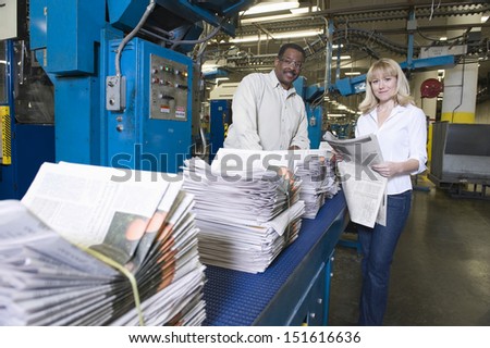 Portrait of a man and woman working in newspaper factory