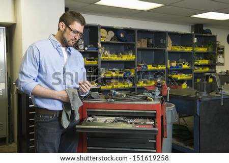 Young man with tools working in workshop