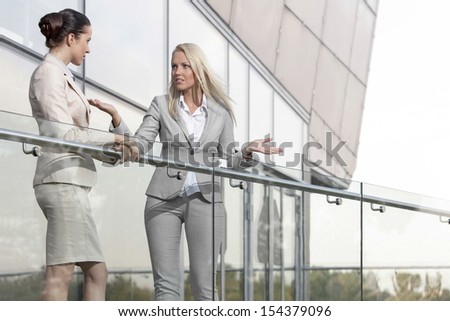 Young businesswoman arguing with female colleague at office balcony
