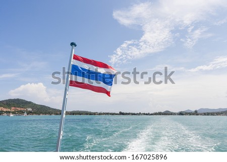 Thailand flag with boat wake at Koh Pha Ngan island