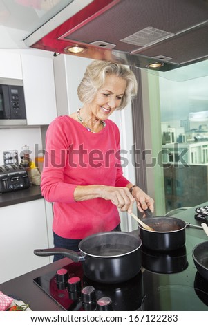 Smiling senior woman preparing food at kitchen counter