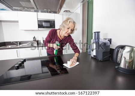 Senior woman cleaning kitchen counter