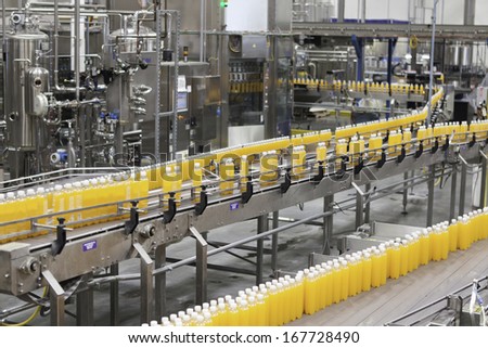 Packed bottles moving on conveyor belt in bottling industry
