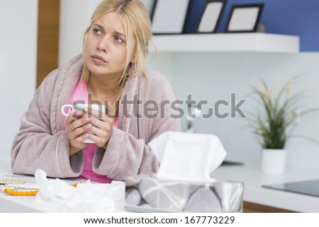 Young woman suffering from cold holding coffee mug