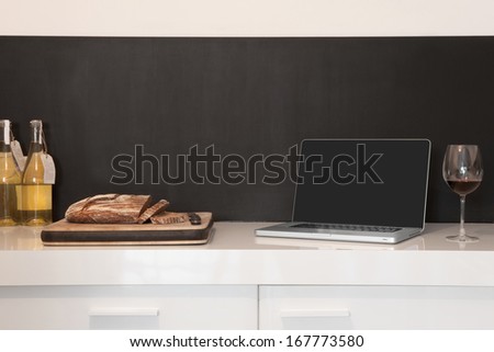 Laptop; wineglass and bread loaf on counter