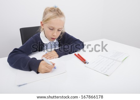 Girl drawing on paper with felt tip pen at table