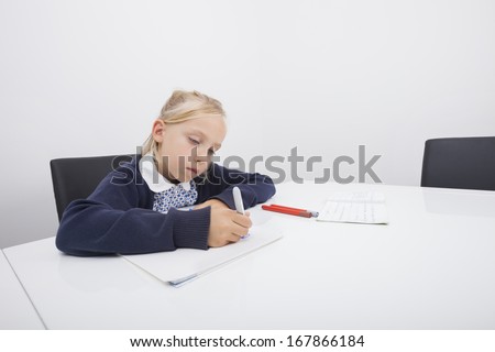 Little girl drawing on paper with felt tip pen at table