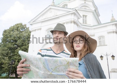 Tourist couple holding map outside St. Casimir Church; Warsaw; Poland