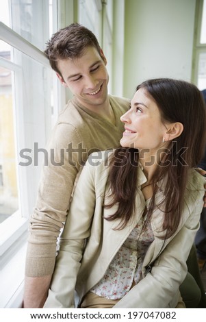 Happy romantic couple looking at each other at home