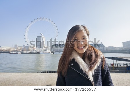 Portrait of happy young woman standing; England; UK
