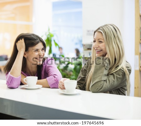 Young businesswomen smiling at cafeteria table