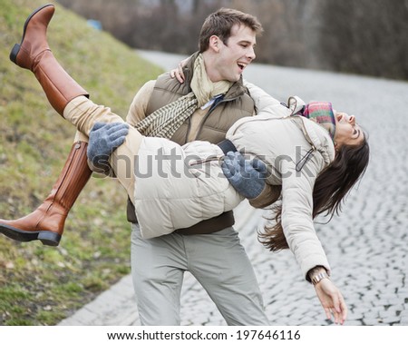 Happy man carrying woman in park