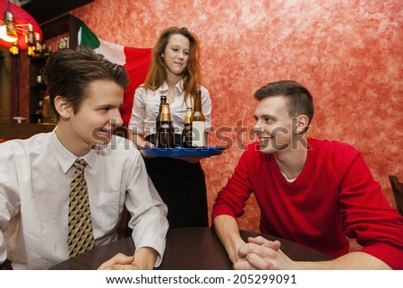 Waitress serving drinks to men in restaurant