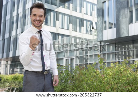 Portrait of successful businessman standing outside office building