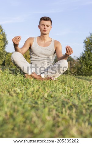 Young man meditating in park