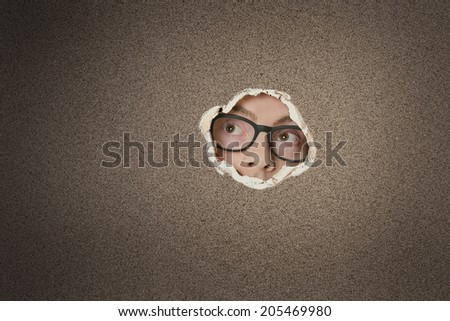 Mid adult Caucasian man looking away from ripped paper hole