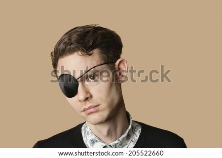 Sad mid adult man wearing eye patch over colored background