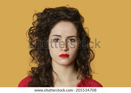 Portrait of a serious woman with black hair over colored background