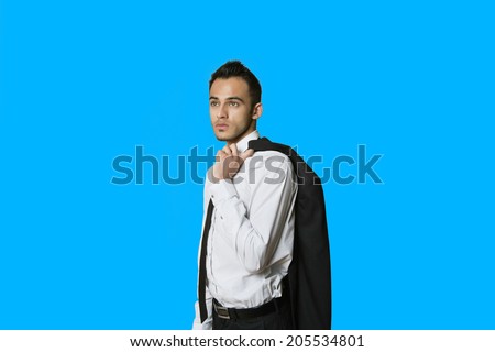 Confident young businessman with suit over shoulder on colored background