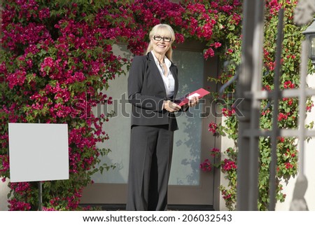 Portrait of a cheerful senior real estate agent with clipboard
