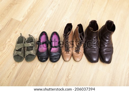 Family shoes placed in a row on hardwood floor