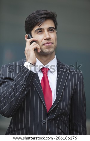 Young Indian businessman communicating on cell phone