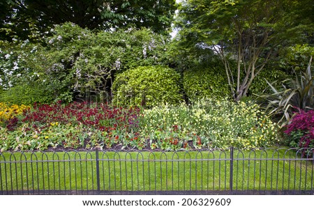 Flower bed and grass behind small fence