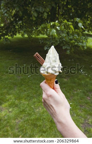 Womans hand holding soft serve ice cream