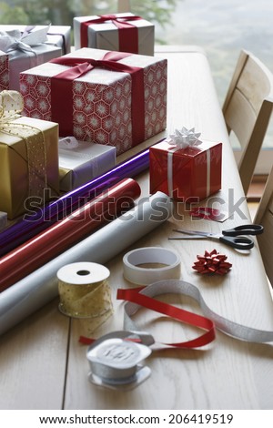 Christmas gifts; wrapping paper and accessories on dining table