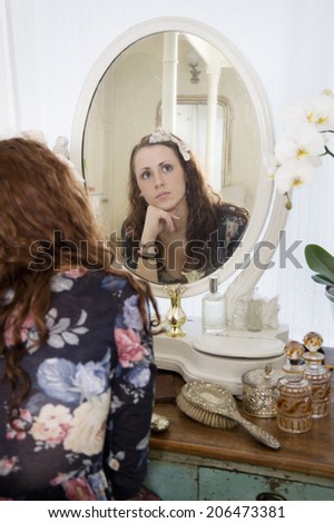 Young woman thinking in front of mirror