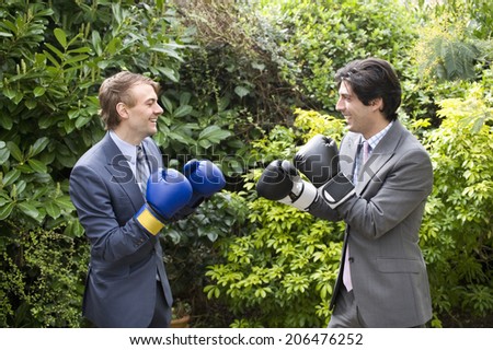 Two young men in suits stage a mock boxing match