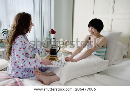Female friend bringing breakfast for her friend