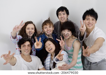 Group portrait of young friends showing peace sign