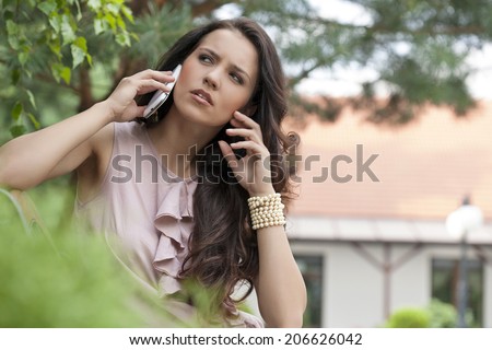Beautiful young woman using cell phone in park