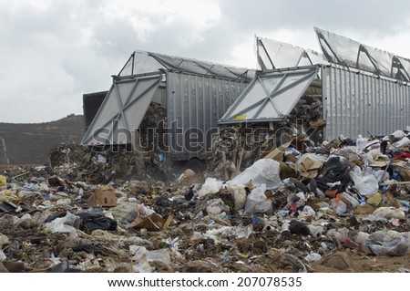 Trucks dumping waste at landfill site