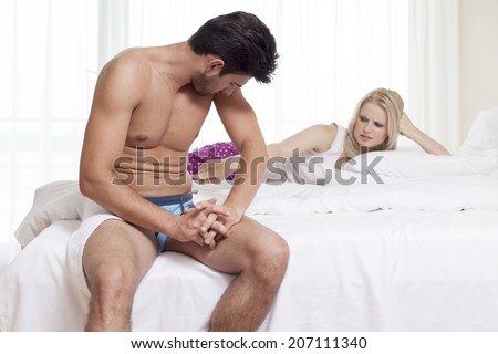 Displeased young woman pointing at man\'s abdomen in hotel room