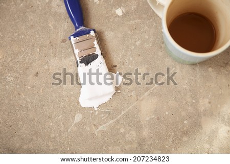 High angle view of coffee mug and paintbrush on floor