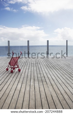 View of horizon over water with baby stroller on wooden dock
